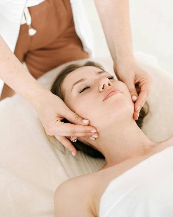 Therapist performing a natural face lift massage on a woman's face