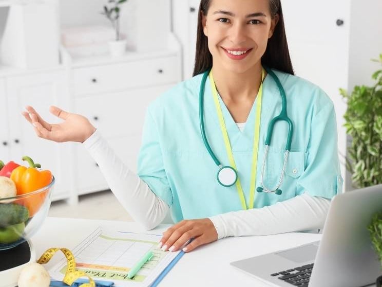 Nutritionist at a desk with healthy food and a personalised diet plan