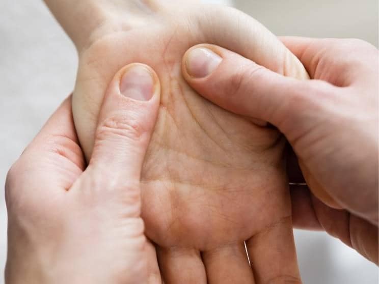 Therapist applying pressure to a patient's foot during reflexology