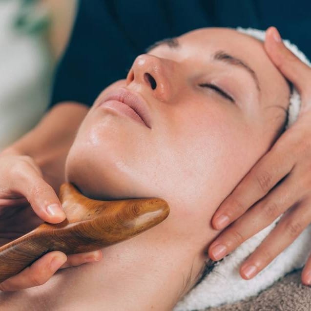 Wood therapy facial massage using a wooden gua sha tool