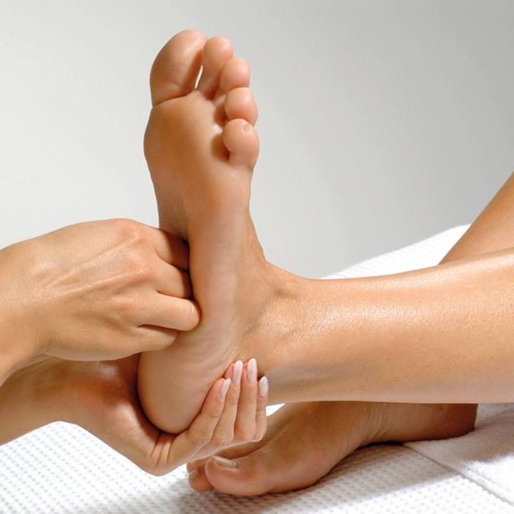 Therapist massaging the sole of a patient's foot