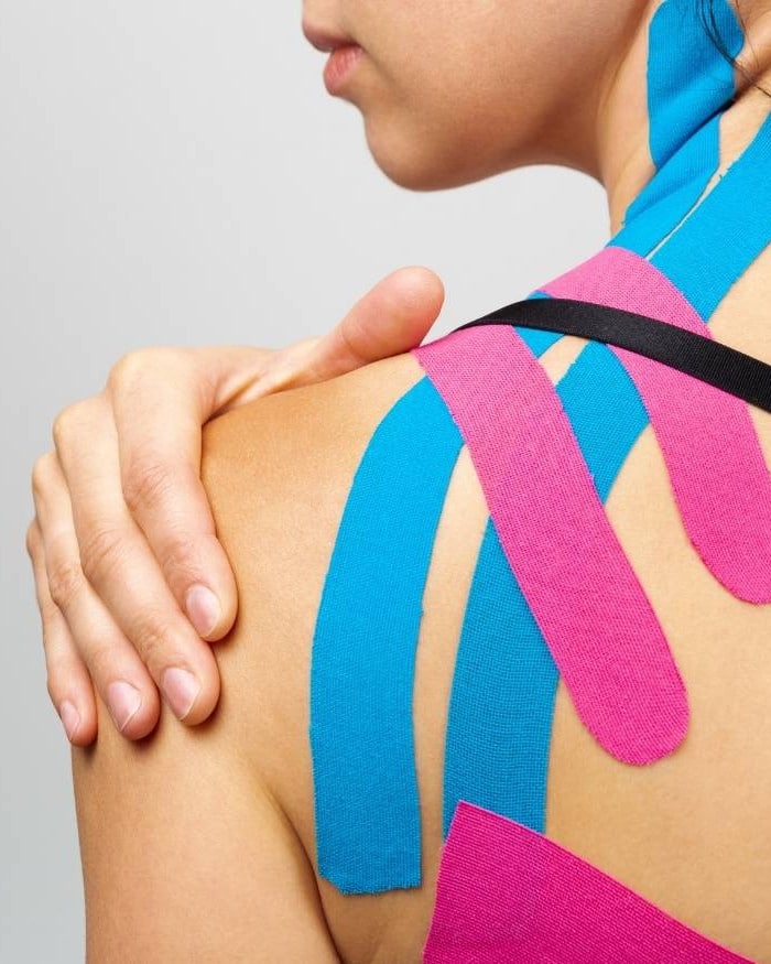 Kinesiology tape applied to a patient's shoulder and neck for sports support